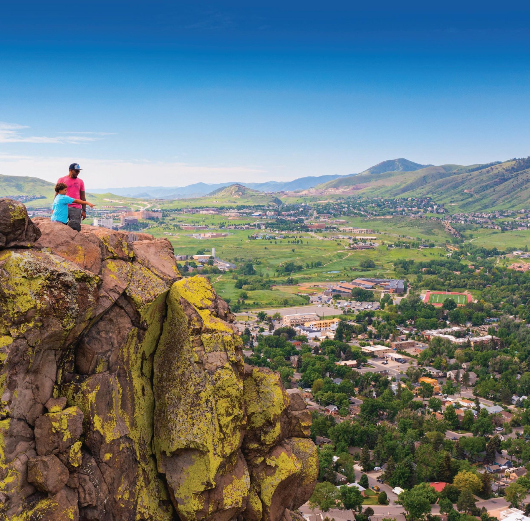 Hikers overlooking Golden from a rocky outcrop