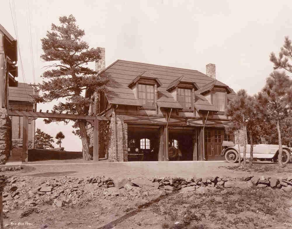 Historic photo of the carriage house with a vintage car
