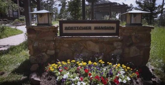 Boettcher Mansion entrance sign with flowers